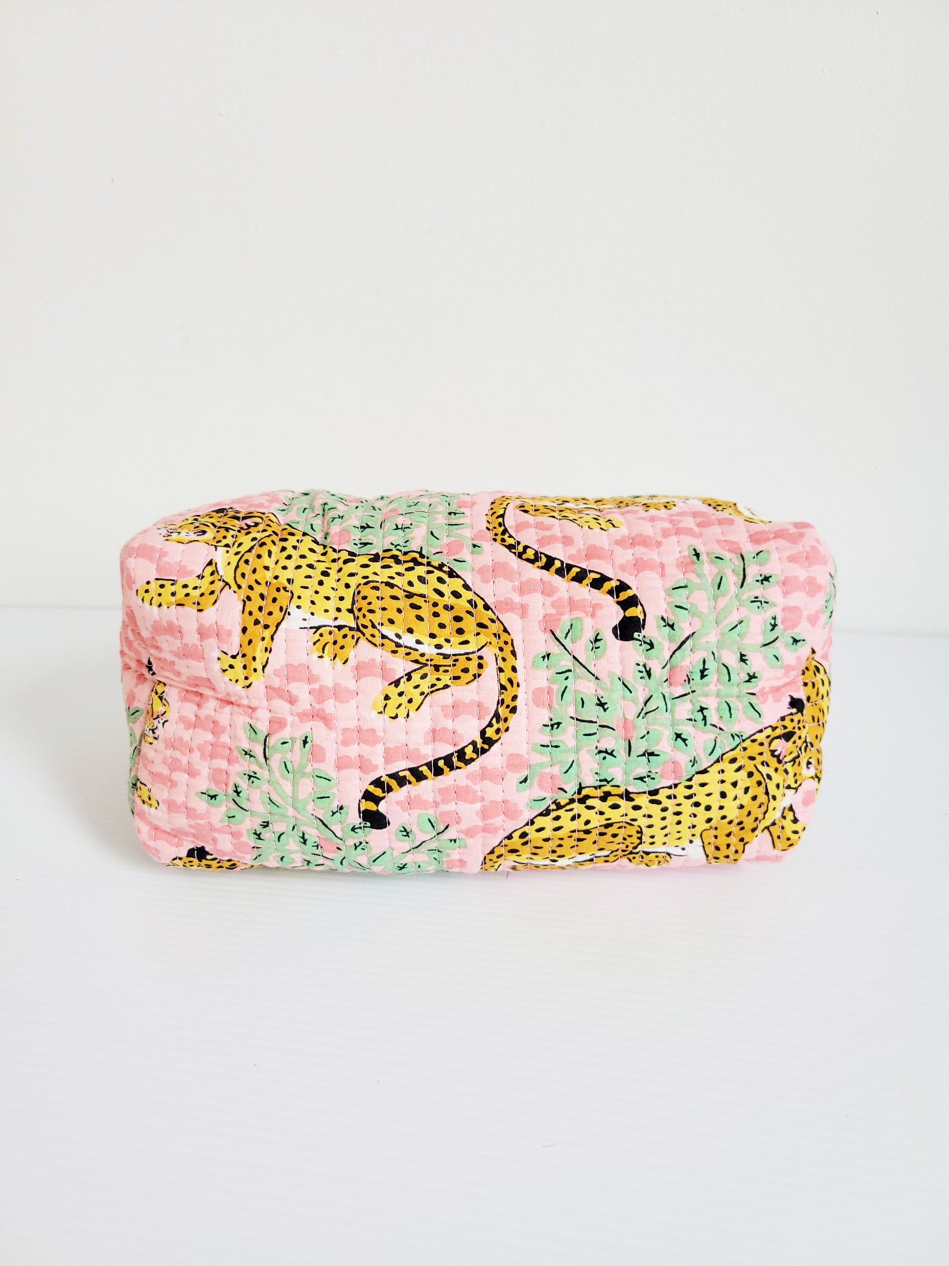 Model holding brown and pink leopard tote.