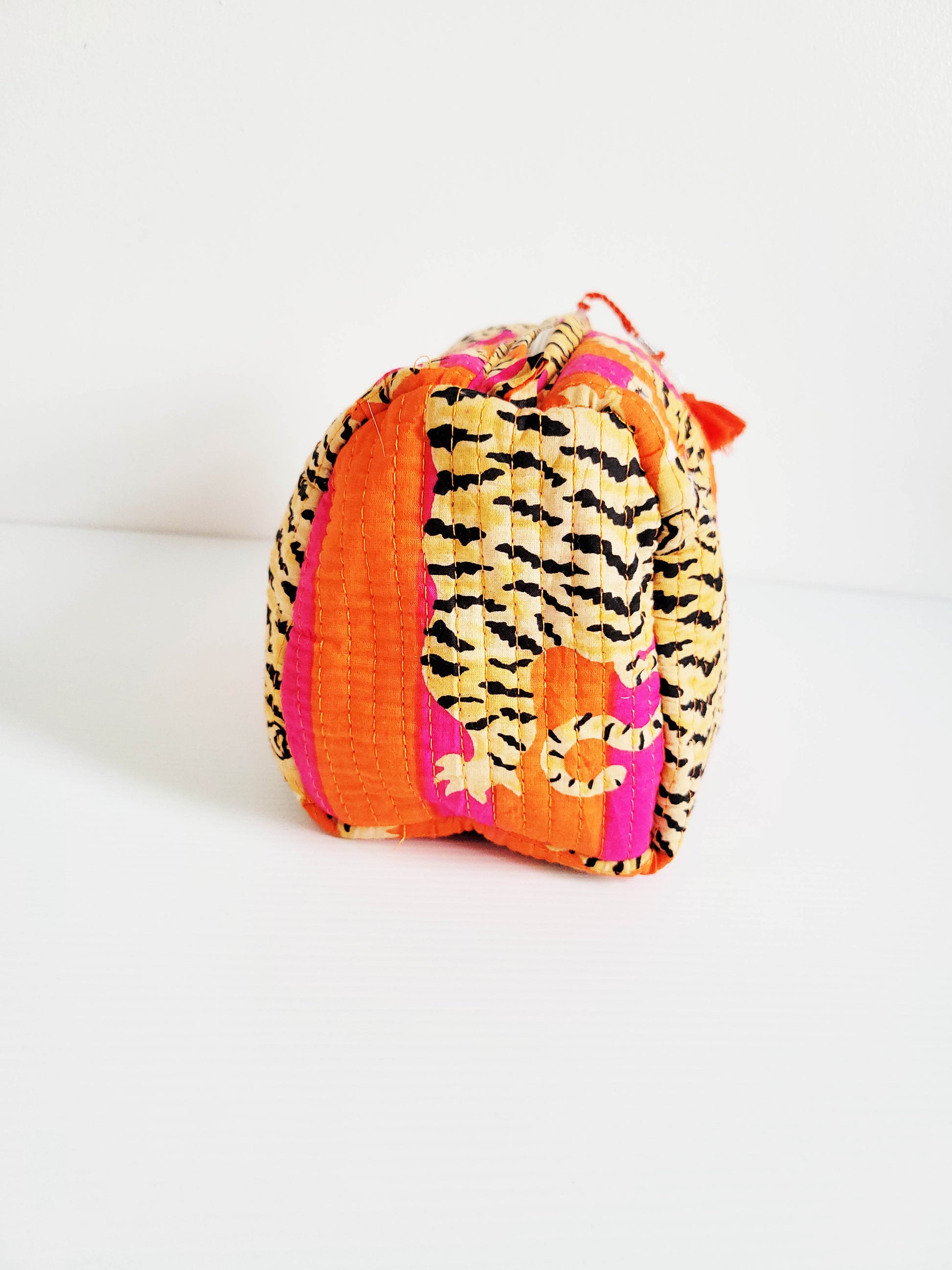 Model holding orange and pink leopard tote.